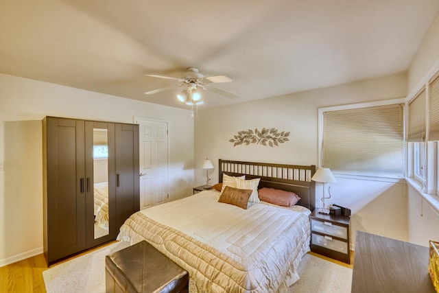 bedroom featuring light wood-style floors, baseboards, and a ceiling fan