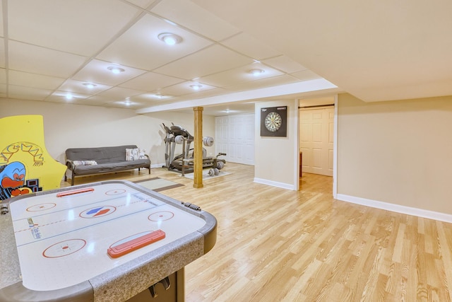 game room with a paneled ceiling, light wood-style flooring, and baseboards