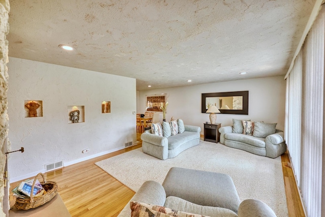 living room featuring recessed lighting, visible vents, baseboards, and wood finished floors