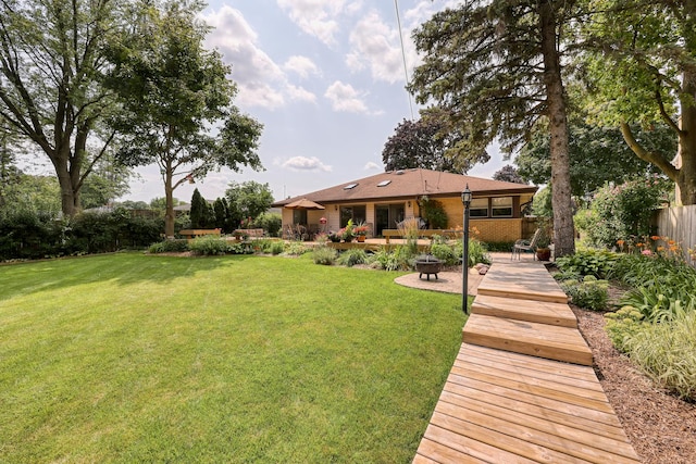 view of yard featuring fence, a fire pit, and a patio