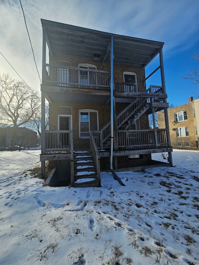 snow covered property with stairs