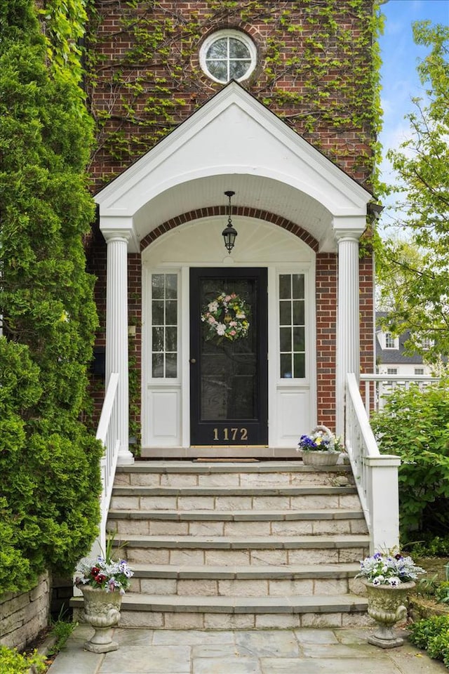 entrance to property featuring brick siding