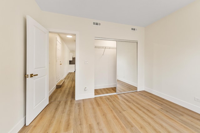 unfurnished bedroom with light wood-style flooring, visible vents, and baseboards