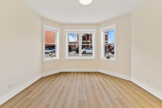 unfurnished room featuring light wood-style floors and baseboards