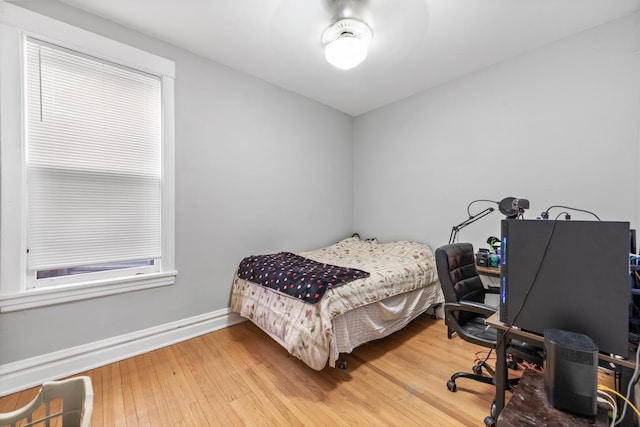 bedroom with baseboards and wood finished floors