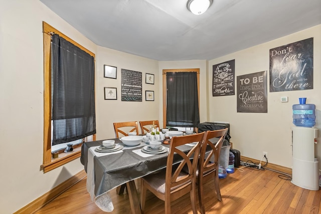 dining space featuring wood-type flooring and baseboards