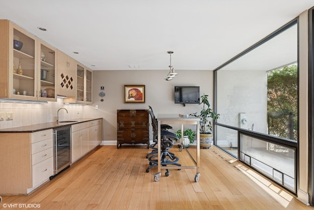 2000 Clendenin Ln, Riverwoods, IL 60015 - kitchen featuring beverage cooler, light wood-style flooring, glass insert cabinets, tasteful backsplash, and dark countertops