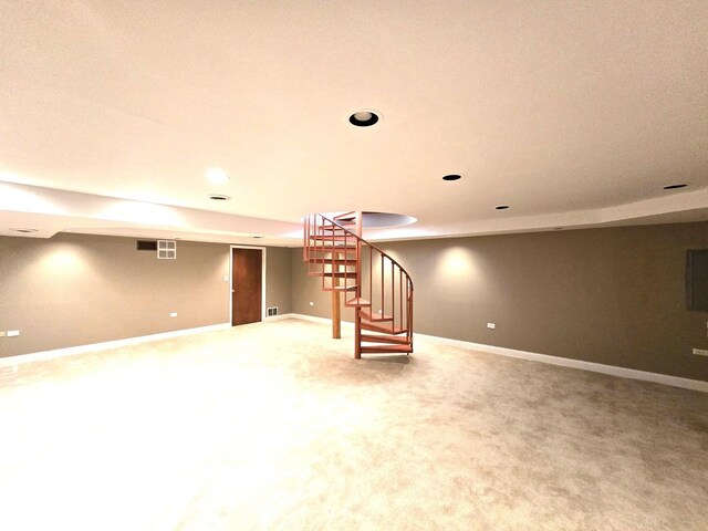 finished basement with visible vents, electric panel, recessed lighting, light carpet, and stairs