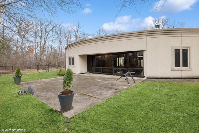 back of house with fence, a yard, a patio, and stucco siding