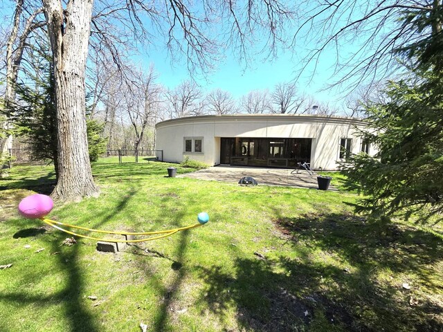 back of house with a lawn, a patio, stucco siding, and fence