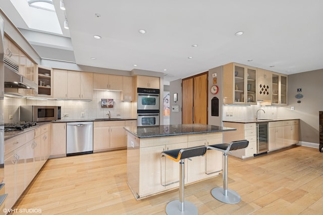 2000 Clendenin Ln, Riverwoods, IL 60015 - kitchen with appliances with stainless steel finishes, wine cooler, light brown cabinetry, a kitchen island, and backsplash