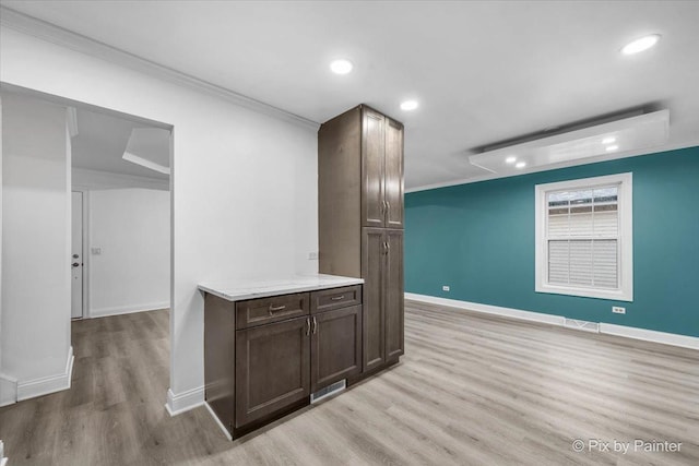 kitchen featuring crown molding, light wood-type flooring, visible vents, and dark brown cabinetry