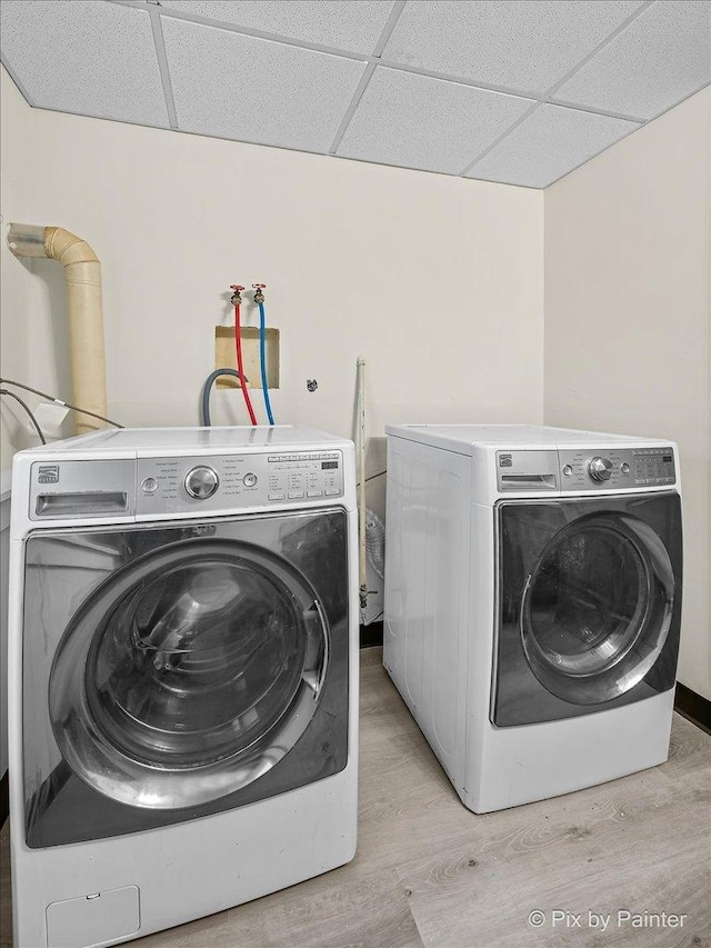 laundry room with light wood-style flooring, laundry area, and washer and clothes dryer