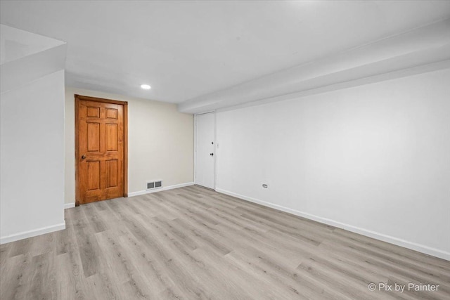 empty room featuring light wood finished floors, visible vents, baseboards, and recessed lighting