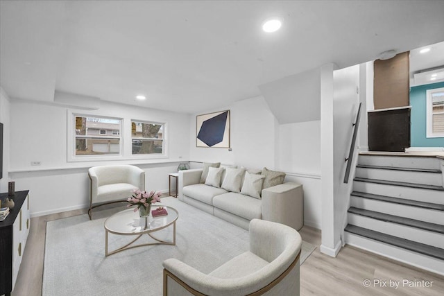 living room featuring baseboards, stairway, recessed lighting, and light wood-style floors