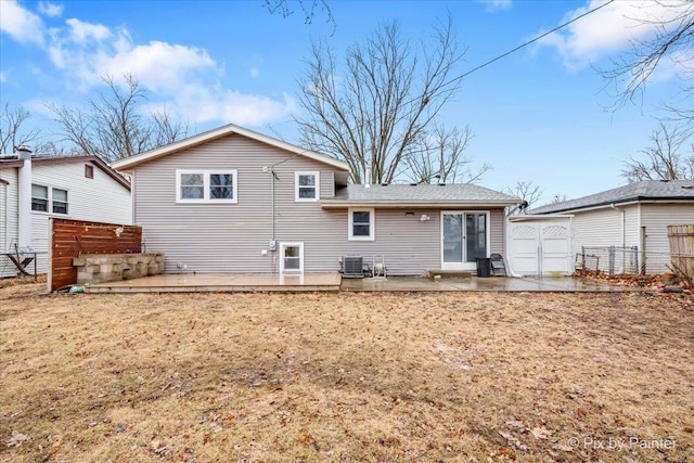 rear view of house featuring central air condition unit, a garage, fence, a yard, and a patio area