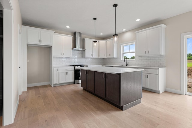 605 Wheatley Dr, Mahomet, IL 61853 - kitchen with wall chimney exhaust hood, stainless steel stove, light wood-style flooring, white cabinets, and recessed lighting