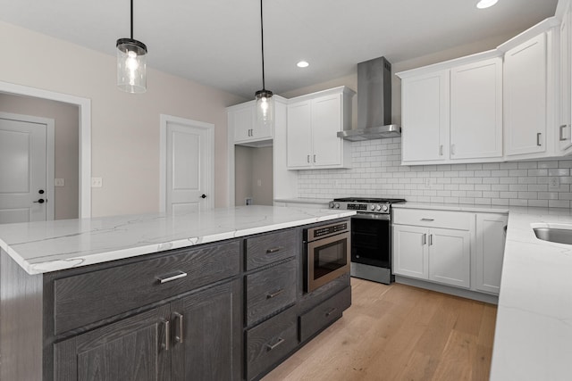 605 Wheatley Dr, Mahomet, IL 61853 - kitchen featuring wall chimney range hood, stainless steel gas stove, white cabinetry, built in microwave, and tasteful backsplash