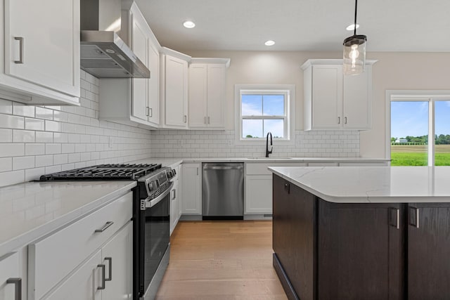 605 Wheatley Dr, Mahomet, IL 61853 - kitchen featuring dishwasher, range with gas stovetop, wall chimney exhaust hood, a sink, and white cabinets