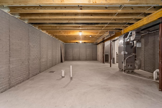 605 Wheatley Dr, Mahomet, IL 61853 - unfinished below grade area featuring heating unit and brick wall