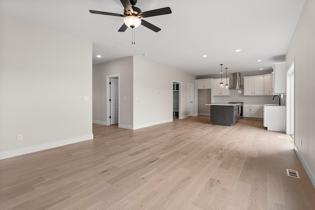 605 Wheatley Dr, Mahomet, IL 61853 - unfurnished living room with a ceiling fan, recessed lighting, light wood finished floors, and baseboards