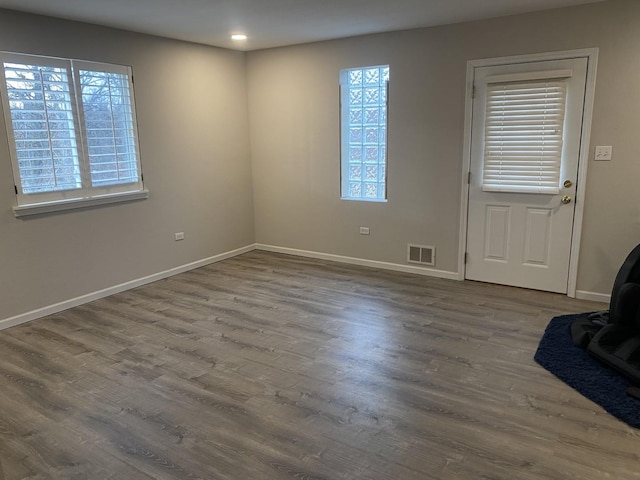 interior space with visible vents, baseboards, and wood finished floors