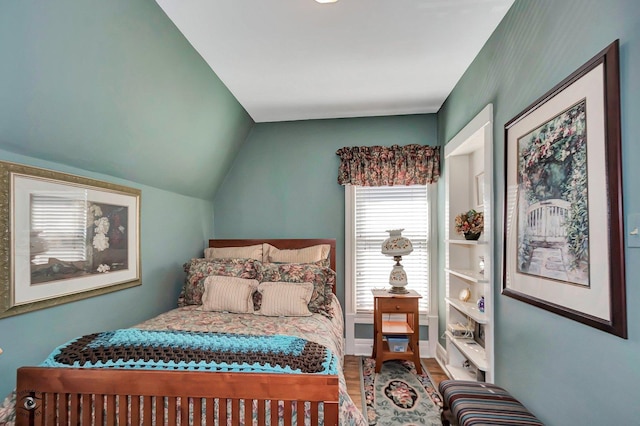 bedroom featuring lofted ceiling and wood finished floors