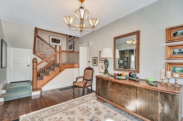 entryway featuring wood finished floors, visible vents, baseboards, stairway, and an inviting chandelier