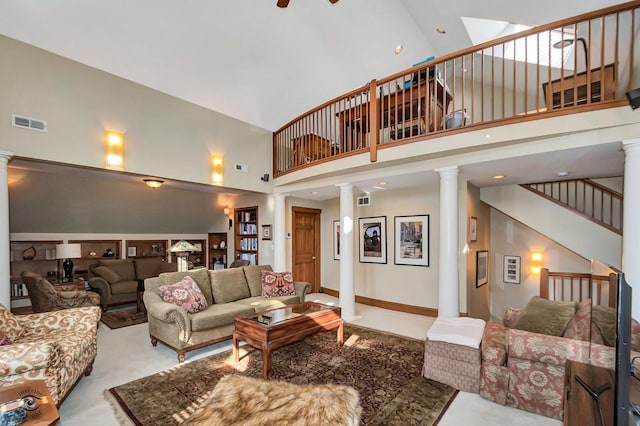 carpeted living area with visible vents, a high ceiling, stairs, and decorative columns