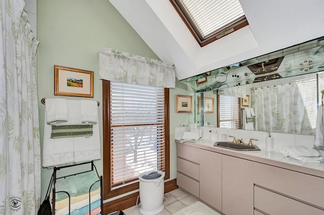 bathroom featuring vaulted ceiling with skylight, tile patterned flooring, and vanity