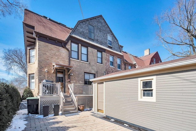 back of property featuring brick siding and a patio area