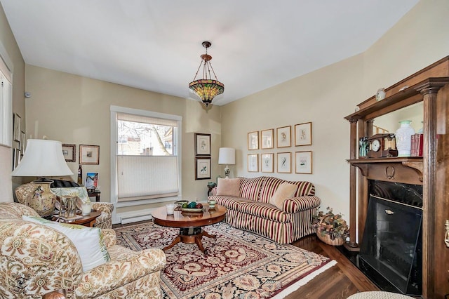 living area with baseboard heating, a fireplace, and wood finished floors