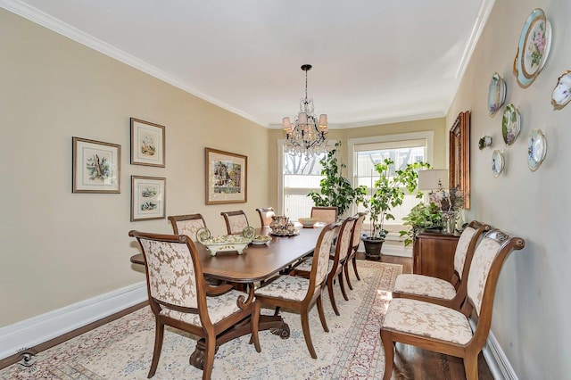 dining space with baseboards, a notable chandelier, wood finished floors, and crown molding