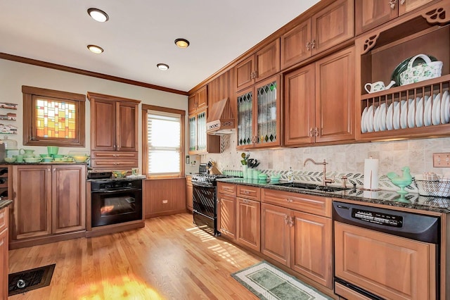 kitchen featuring light wood-style flooring, brown cabinetry, ornamental molding, a sink, and black appliances