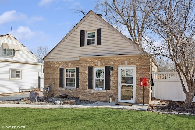 bungalow with a front lawn, fence, and brick siding