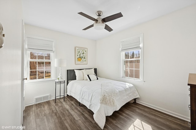 bedroom with visible vents, multiple windows, and wood finished floors