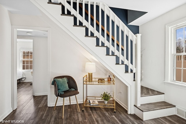 stairway featuring wood finished floors, visible vents, and baseboards