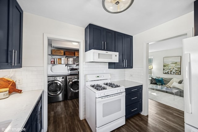 kitchen featuring white appliances, dark wood-style flooring, backsplash, and washer and clothes dryer