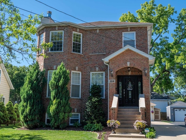 view of front facade with a garage, a chimney, an outbuilding, and brick siding