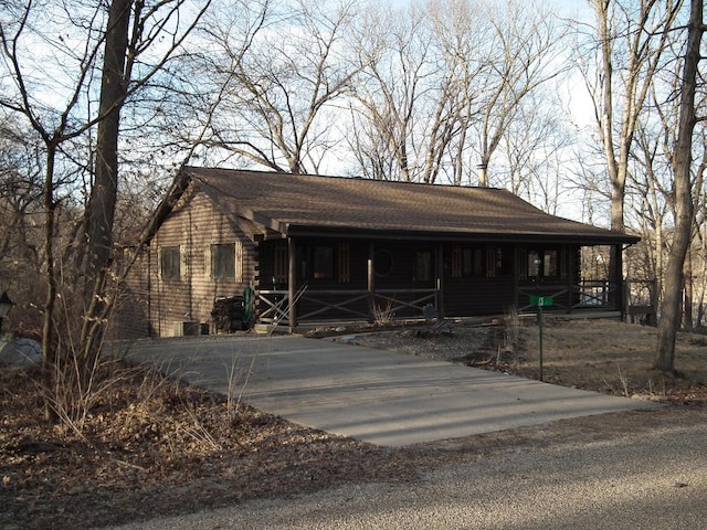 view of front of house featuring log exterior and a porch