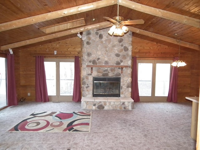 unfurnished living room with lofted ceiling with beams, wood walls, a fireplace, and wood ceiling