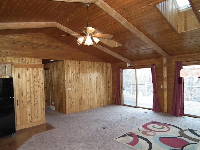 unfurnished living room featuring wood walls, vaulted ceiling with skylight, and a wealth of natural light