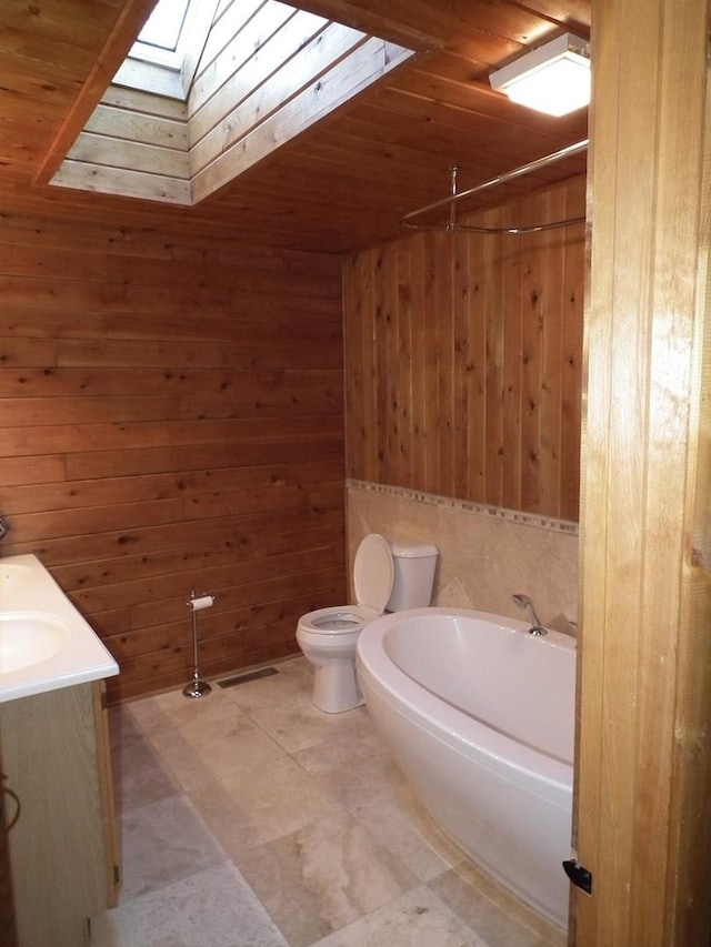 full bathroom featuring a washtub, a skylight, wooden walls, and toilet