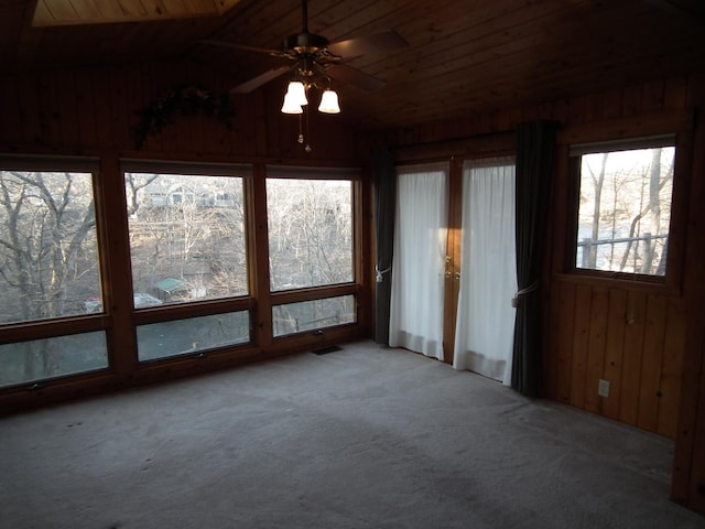 unfurnished sunroom featuring lofted ceiling, wooden ceiling, visible vents, and a ceiling fan