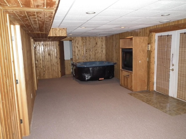 finished basement featuring wood walls and carpet flooring