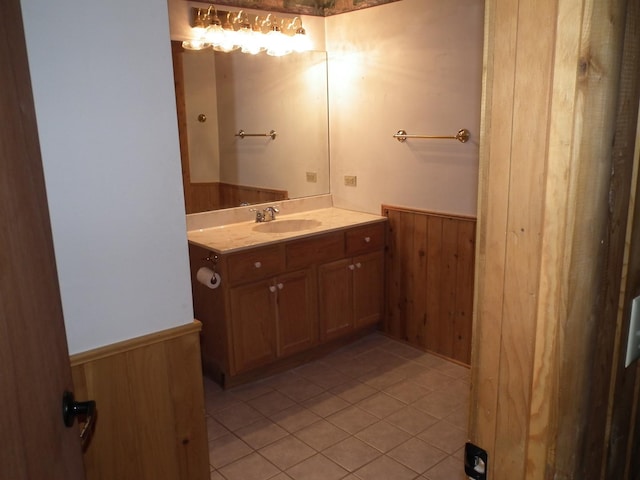 bathroom featuring a wainscoted wall, wooden walls, and vanity