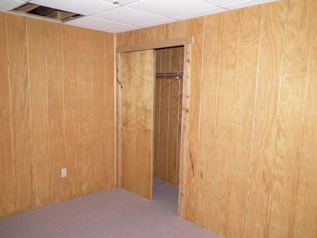 unfurnished room with carpet and wooden walls