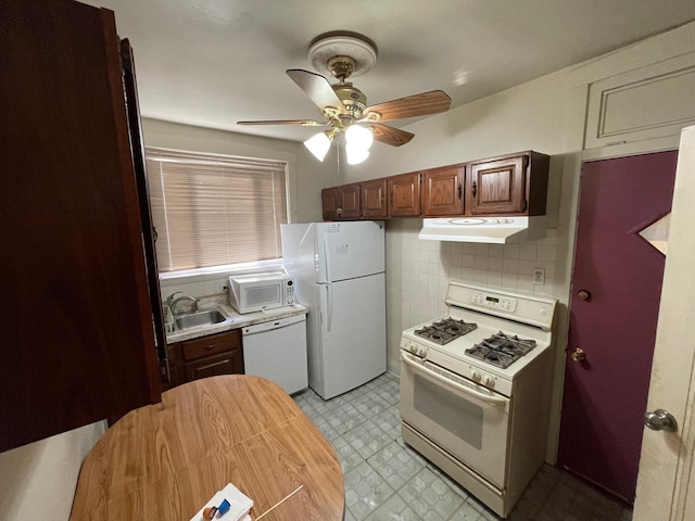 kitchen featuring light floors, light countertops, a sink, white appliances, and under cabinet range hood