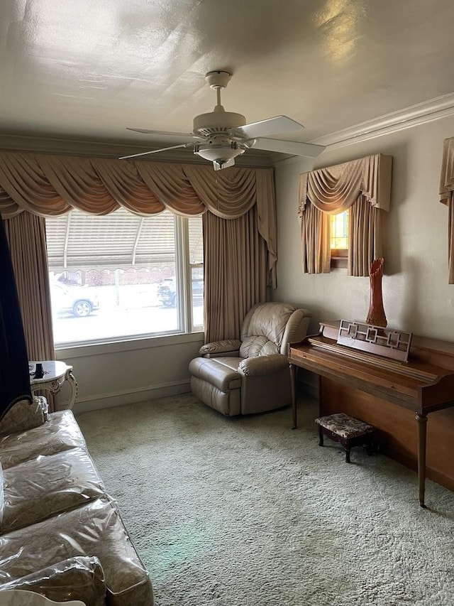 living area with carpet floors, baseboards, and a ceiling fan