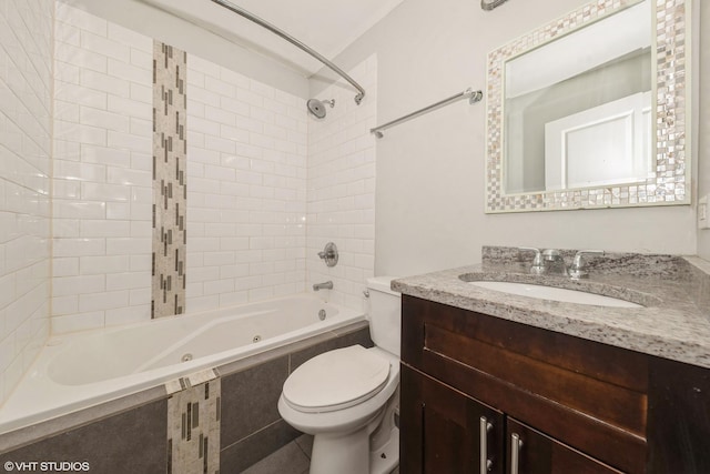 bathroom featuring toilet, a combined bath / shower with jetted tub, and vanity